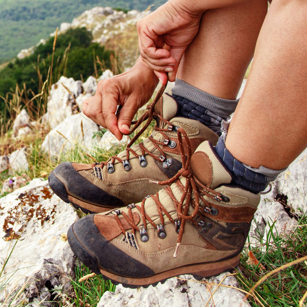 Woman tighting her brown hiking shoes